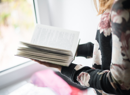 overhead view of hands holding a blank bookの写真素材