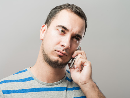 casual young man talking on the phoneの写真素材