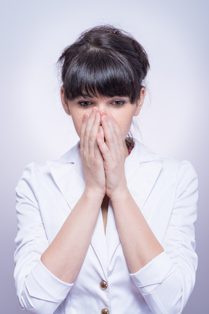 portrait of beautiful shy female stylish woman covering her faceの写真素材