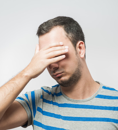 Depressed young man  holding head in handsの写真素材