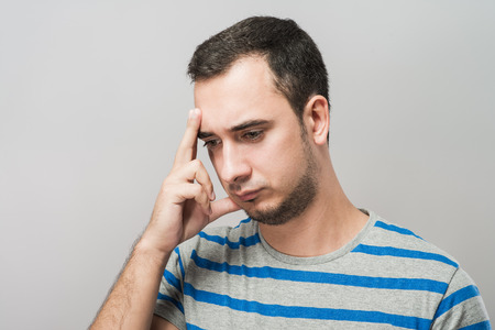 Depressed young man  holding head in handsの写真素材