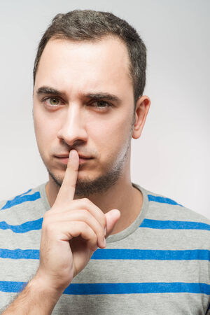 Man holding finger near the mouthの写真素材