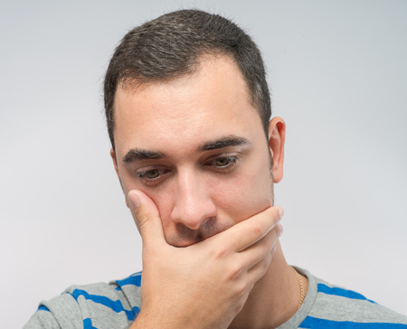 Depressed young man  holding head in handsの写真素材