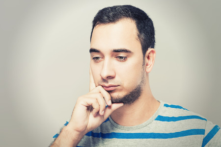 Depressed young man  holding head in handsの写真素材