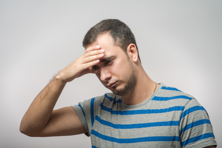 Depressed young man  holding head in handsの写真素材