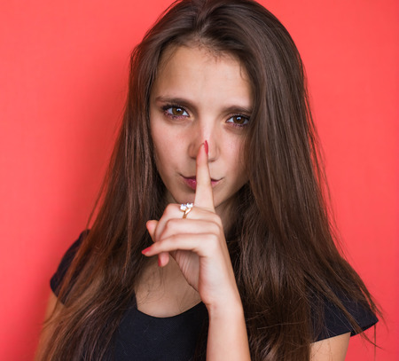 Secret woman. Female showing hand silence signの写真素材