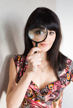 The woman with a magnifier in a handの写真素材