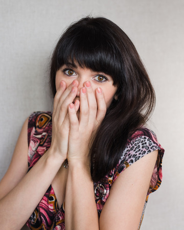 Portrait of young woman covering her face with hands.の写真素材