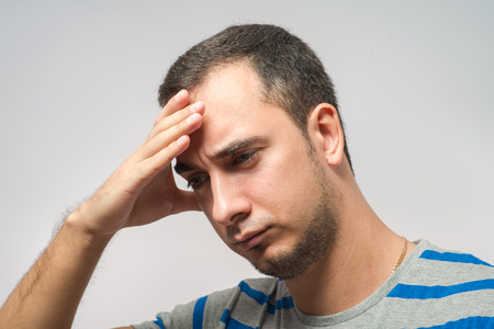 Depressed young man  holding head in handsの写真素材