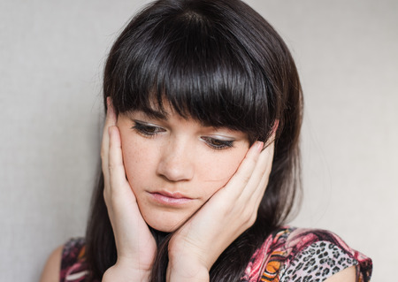 Woman with headache holding head with hands and have grimace on his face.の写真素材