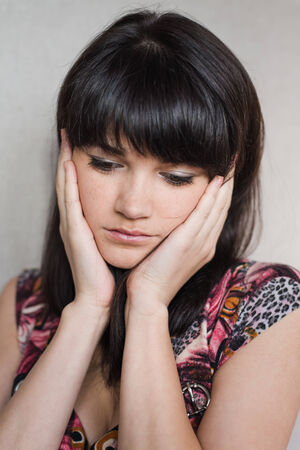 Woman with headache holding head with hands and have grimace on his face.の写真素材