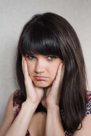Woman with headache holding head with hands and have grimace on his face.の写真素材