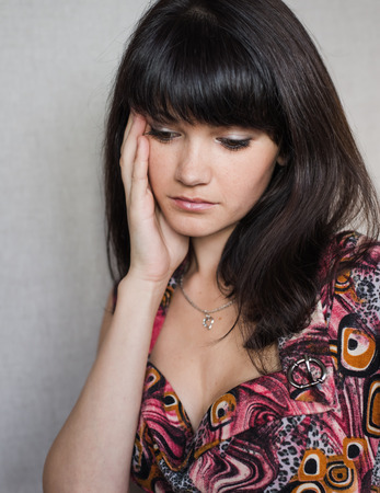 Woman with headache holding head with hands and have grimace on his face.の写真素材