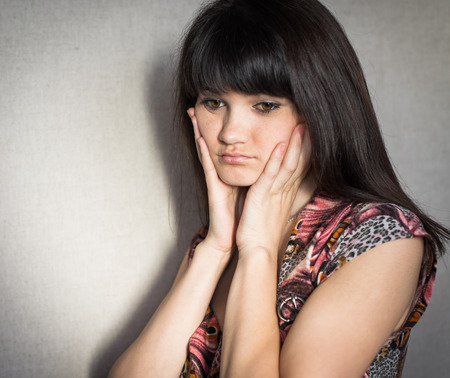Woman with headache holding head with hands and have grimace on his face.の写真素材