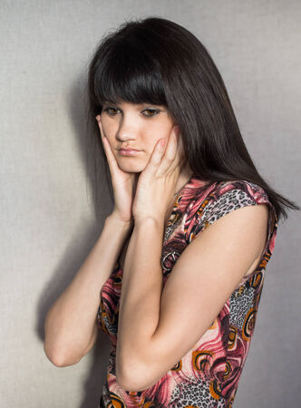 Woman with headache holding head with hands and have grimace on his face.の写真素材