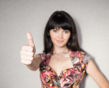 A young, successful woman holds his thumb up.の写真素材