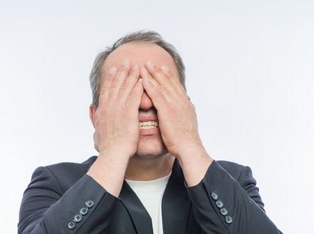 Businessman covering his face with both handsの写真素材