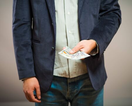 Business executive in formal suit giving money as a bribeの写真素材