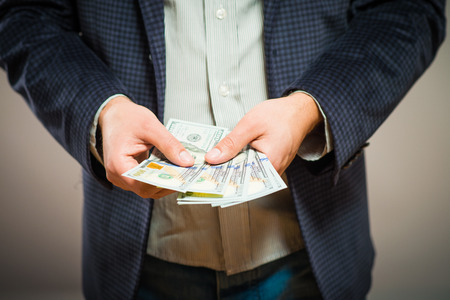 Business executive in formal suit giving money as a bribeの写真素材