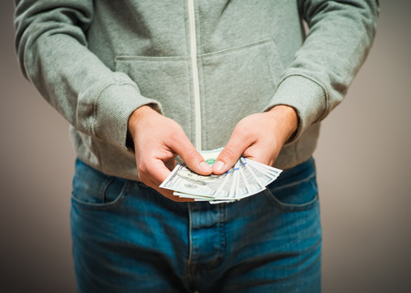 Business executive in formal suit giving money as a bribe