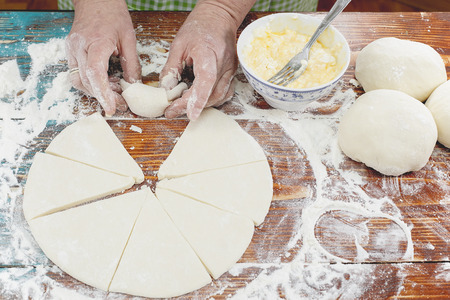 Baker making mini croissants