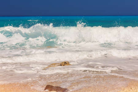 Colorful ocean waves and sand. Beautiful natural scenery of the sea on the golden sandy shore during daytimeの写真素材