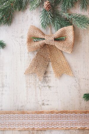 Christmas card with rustic burlap  bow. Top view, vintage toned image, blank spaceの写真素材