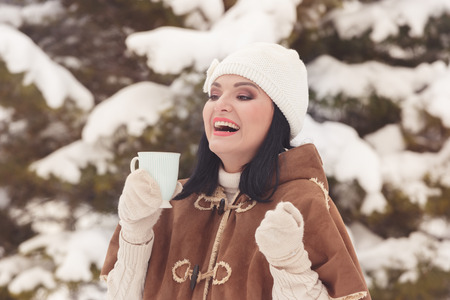 Happy woman with  tea or coffee cup, enjoying  outdoors in a sunny winter day, vintage toning