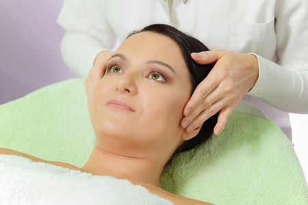Woman Enjoying a Facial Massage in Spa Centerの写真素材
