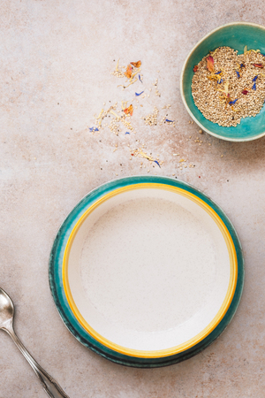 Empty eating bowl and plate next to sesame seeds, set for mealの写真素材