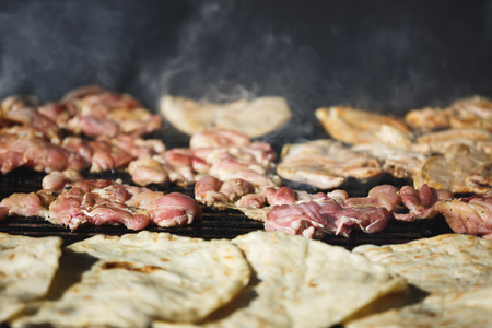 Delicious meats being prepared on open grill, outdoor kitchen, selective focus