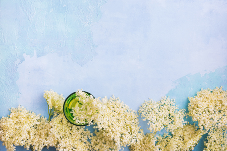 Elderflower cordial syrup with lemon and  elder branches on a rustic blue  wooden table. Top view, blank spaceの写真素材