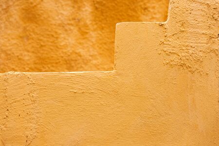 Texture Of Bright Yellow Orange Colored Old Stone Wall and  Steps, close upの写真素材