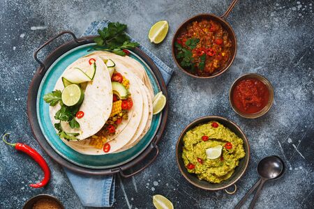 Vegetarian breakfast burrito and ingredients. Homemade tortillas stacks with veggie mince, vegetables, guacamole and avocado . Filling, colorful and delicious. Top view, blank spaceの写真素材