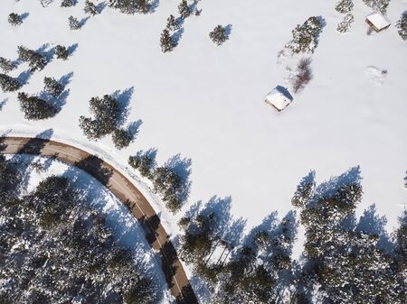 Snowy Mountain Landscape. Aerial view of a forest and road under the snow, copy spaceの写真素材