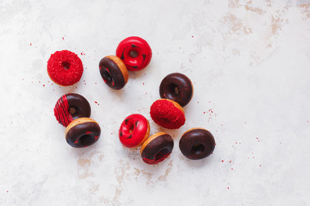 Mini American chocolate donuts splashed on the rustic white background. Top view, blank spaceの写真素材