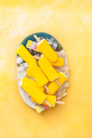 Fruity ice pop . Vegan various colorful ice lollies on a plate. Top view, blank space