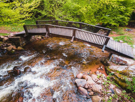 Small wooden bridge over river in green forest. Balkan mountains, Serbia. Nature outdoors travel destination.  Aerial, drone viewの写真素材