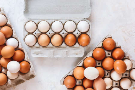 Fresh white and brown hen's eggs in eco cardboard  tray on kitchen wood  countertop