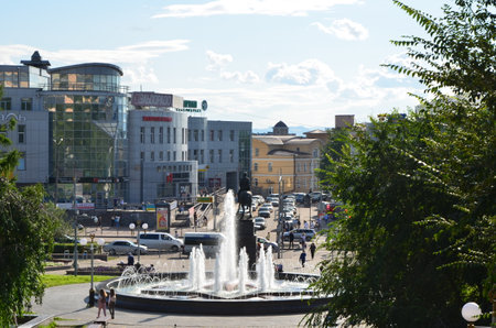 This picture shows a street with buildings and monument with fountainの写真素材