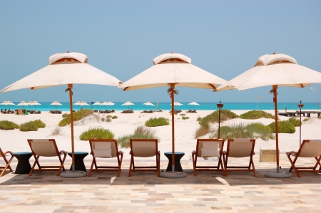 Sunbeds and umbrellas at the Beach of luxury hotel, Abu Dhabi, UAEのeditorial素材