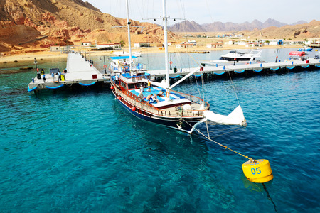 SHARM EL SHEIKH, EGYPT -  DECEMBER 4  The sail yacht with tourists is near pier in harbor of Sharm...