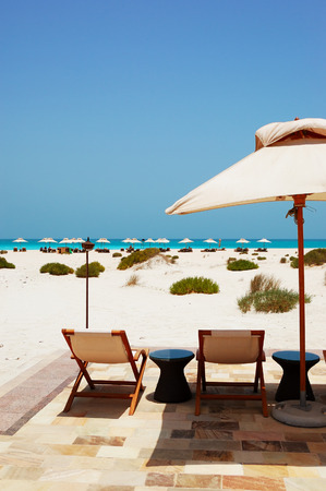 Sunbeds and umbrellas at the beach of luxury hotel, Abu Dhabi, UAEのeditorial素材