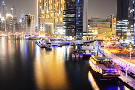 DUBAI, UAE - SEPTEMBER 11: The night illumination of Dubai Marina and Dhow boat on September 11, 2013 in Dubai, UAE.  It is an artificial canal city, built along a two mile (3 km) stretch of Persian Gulf shoreline.のeditorial素材
