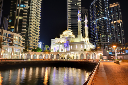DUBAI, UAE - NOVEMBER 19: The night illumination of Dubai Marina and Muslim Mosque on November 19, 2017 in Dubai, UAE. It is an artificial canal city, built along a two mile (3 km) stretch of Persian Gulf shoreline.のeditorial素材