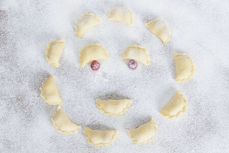 The raw traditional Ukrainian hand-made vareniki (dumpling) with cherry insideの写真素材