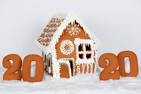 The hand-made eatable gingerbread house, 2020 inscription, snow decoration, on white background