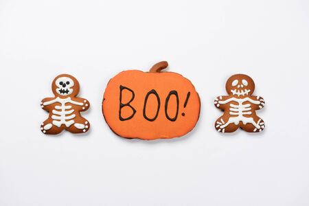 The hand-made eatable gingerbread Halloween sceletons and pumpkin on white backgroundの写真素材