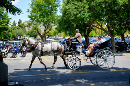 KERKYRA, GREEES - MAY 17: The tourists are in horse-drawn carriage on street on May 17, 2016 in...