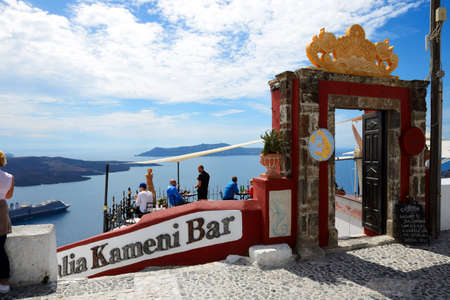 FIRA, GREECE - MAY 17: The view on Fira town and tourists enjoying their vacation in a bar on May 17, 2014 in Fira, Greece. Up to 16 mln tourists is expected to visit Greece in year 2014.のeditorial素材